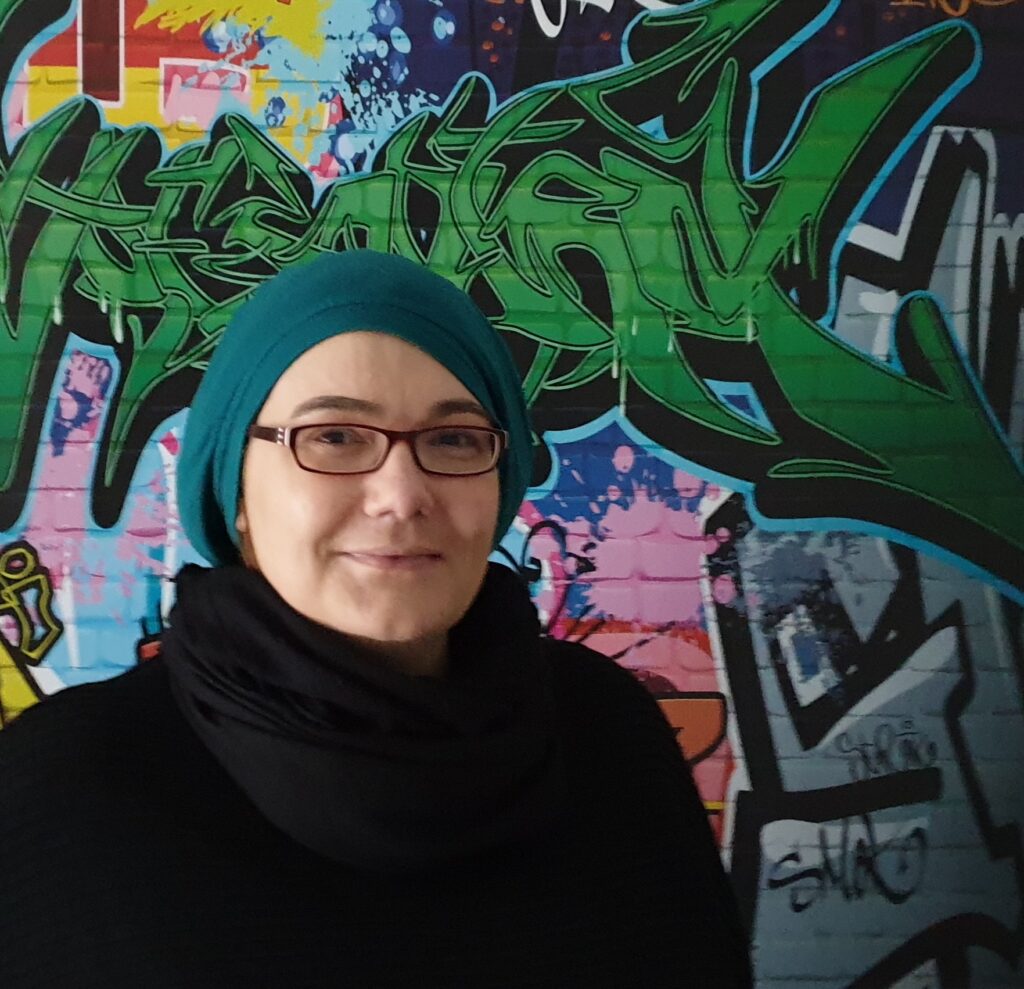 Ulrike Suwwan, co-founder and backer stands in front of a graffiti